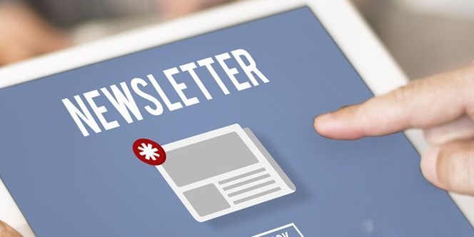 Ein Finger zeigt auf ein Tablet-Bildschirm mit der Aufschrift "Newsletter". Auf dem Bildschirm ist ein Symbol eines Briefes mit einem Sternchen darauf zu sehen. Der Hintergrund ist unscharf.
